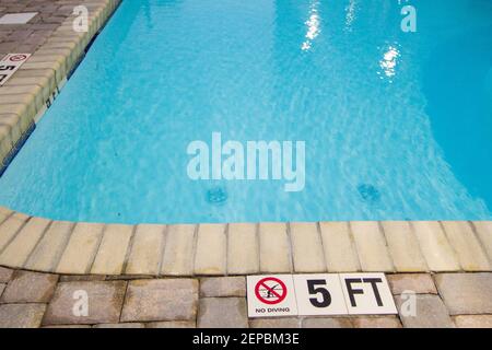 Flaches Ende des Pools mit einem Schild, das darauf hinweist, dass man nicht tauchen darf. Stockfoto