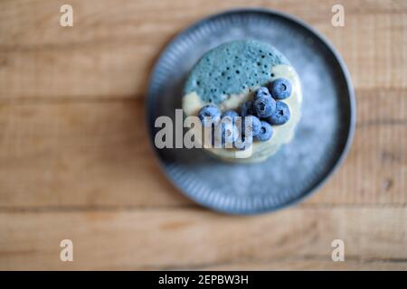 Blaue Pfannkuchen mit Heidelbeere und Karamellsauce auf Vintage-Teller. Stockfoto