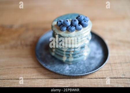 Blaue Pfannkuchen mit Heidelbeere und Karamellsauce auf Vintage-Teller. Stockfoto