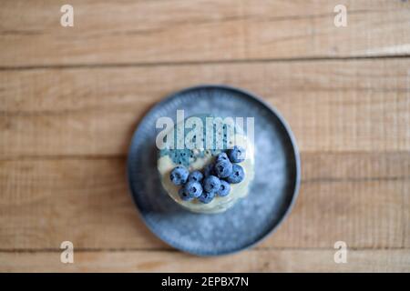 Blaue Pfannkuchen mit Heidelbeere und Karamellsauce auf Vintage-Teller. Stockfoto