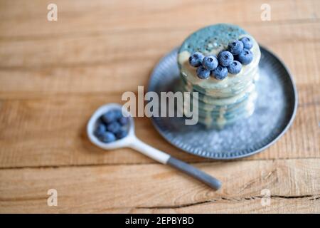 Blaue Pfannkuchen mit Heidelbeere und Karamellsauce auf Vintage-Teller. Stockfoto