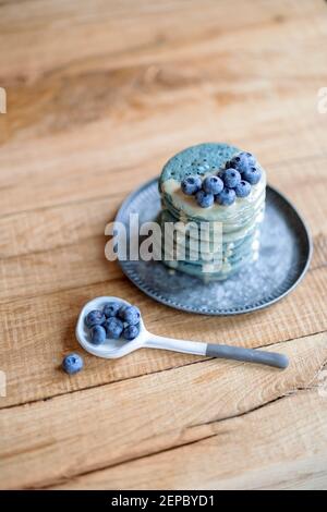 Blaue Pfannkuchen mit Heidelbeere und Karamellsauce auf Vintage-Teller. Stockfoto