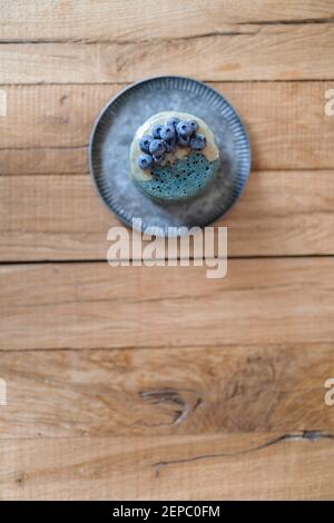 Blaue Pfannkuchen mit Heidelbeere und Karamellsauce auf Vintage-Teller. Stockfoto