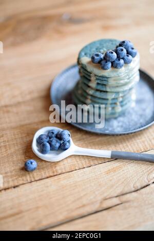 Blaue Pfannkuchen mit Heidelbeere und Karamellsauce auf Vintage-Teller. Stockfoto