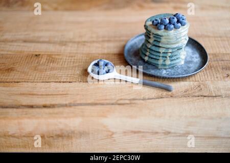 Blaue Pfannkuchen mit Heidelbeere und Karamellsauce auf Vintage-Teller. Stockfoto