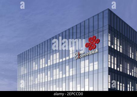 Hongkong, China. Februar 19, 2021. Nur für redaktionelle Verwendung, 3D CGI. China Unicom Corporation Beschriftungslogo auf Glasgebäude. Arbeitsplatz-Telekommunikation Stockfoto