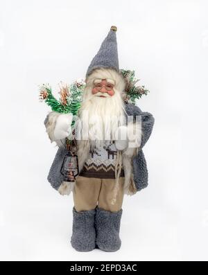 Ein skandinavischer Stil Santa Claus Puppe hält Weihnachtsbaum Äste und isoliert vor einem gemischten grauen Hintergrund. Stockfoto