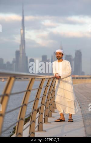 emirati man in Al Jaddaf Waterfront in Dubai mit Burj Khalifa im Hintergrund Stockfoto