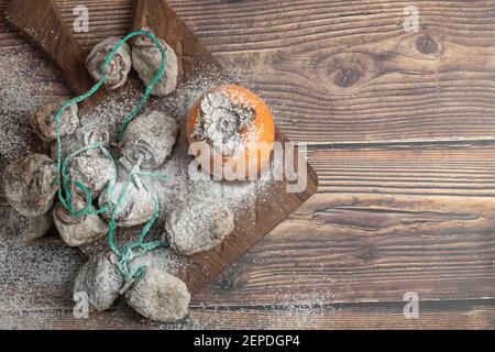 Köstliche frische und getrocknete Kaki-Früchte auf Holzbrett Stockfoto