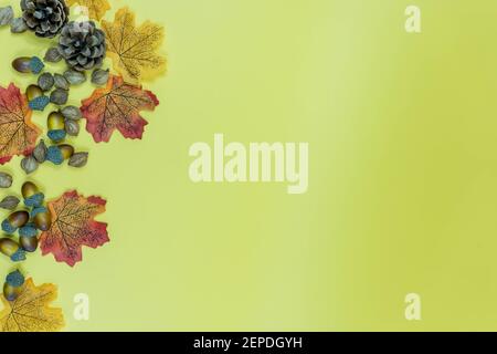 Tannenzapfen, Herbstblätter und Samen auf gelbem Hintergrund. Herbst Thanksgiving Hintergrund mit Copy Space Stockfoto
