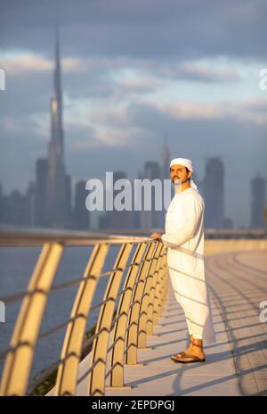 emirati man in Al Jaddaf Waterfront in Dubai mit Burj Khalifa im Hintergrund Stockfoto