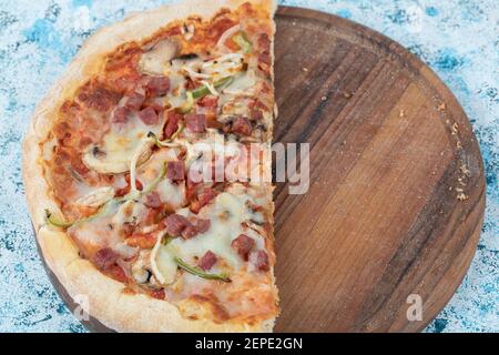 Leckere Pizza. Die Hälfte der gemischten Pizza auf Holzbrett Stockfoto