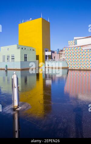 Gelber Turm des Museums spiegelt sich im gefrorenen Kanal in Groningen, Niederlande Stockfoto