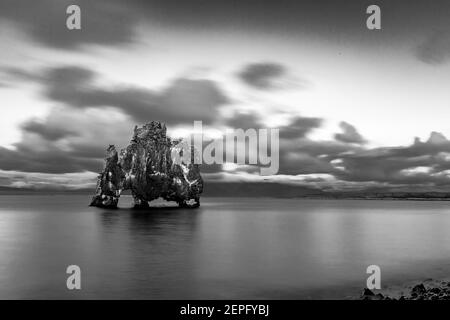 Island, die schöne Felsformation auch bekannt als der trinkende Drache im Atlantischen Ozean in der Nähe von Hvitserkur in schwarz-weiß, Langzeitbelichtung Reise Fotografie in der blauen Stunde Stockfoto