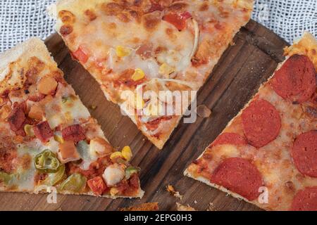 Nahaufnahme Foto von verschiedenen Arten von Pizza Scheiben auf Holzbrett Stockfoto