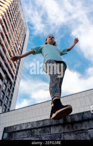 Blick von unten auf stilvolle Teenager in der Nähe Wolkenkratzer zu Fuß im Freien Stockfoto