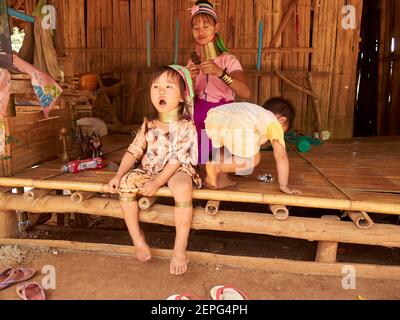 Kinder aus Karens Stammesfamilie spielen mit ihrer Mutter Auf der Veranda ihres Bambushauses Stockfoto