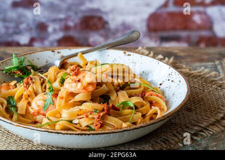 Tigergarnelen in Tomaten, Chili und Mandelpesto mit Fettuccine Pasta Stockfoto