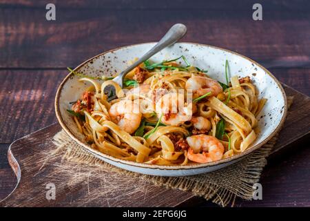 Tigergarnelen in Tomaten, Chili und Mandelpesto mit Fettuccine Pasta Stockfoto