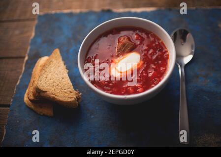 Traditionelles ukrainisches Gericht Borscht mit Sauerrahm und Brot Ein Holztisch Stockfoto