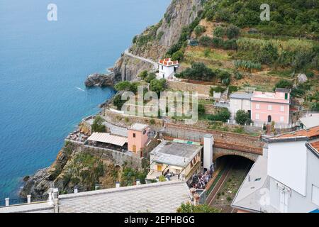 Riomaggiore, Italien- 17. September 2018:Blick von oben auf die berühmte ligurische Stadt Cinque Terre, mit Bahnhof, Meer und Hügel Stockfoto