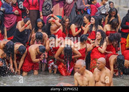 Kathmandu, Nepal. Februar 2021, 27th. Hindu-Anhänger nehmen das heilige Bad während der traditionellen Prozession am letzten Tag des Festivals.Shree Swasthani Barta Katha oder Madhav Narayan Festival ist das Monat lang Festival, das dem frommen Fasten, dem heiligen Bad und den Ritualen gewidmet ist. Eifrige Anhänger schlossen das einmonatige Fasten für besseres Leben und Wohlstand ab, das Festival ist Lord Shiva gewidmet. Kredit: SOPA Images Limited/Alamy Live Nachrichten Stockfoto
