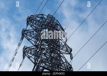 Oberer elektrischer Turm mit angeschlossenen Stromleitungen Stockfoto