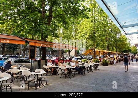 Die berühmte Luxus-Einkaufsmeile Königsallee in Düsseldorf mit Straßencafés an einem Sommertag. Stockfoto