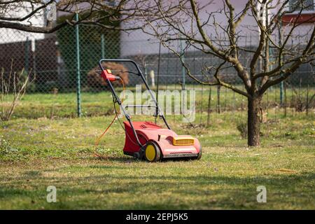 Verticutter im Garten, Gartengeräte. Elektrischer Rasensprenger. Verticutting Gras im Hinterhof im Frühjahr Stockfoto