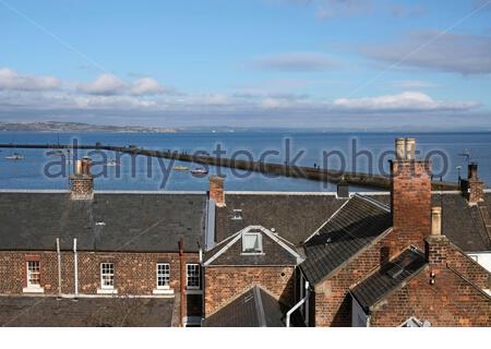 Blick über die Dächer in Richtung Granton Hafen und Wellenbrecher in der Firth of Forth Mündung, Edinburgh, Schottland Stockfoto