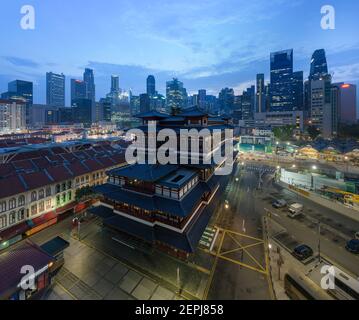 Der Buddha Zahnrelikt Chinesischer Tempel, der bei Sonnenaufgang erleuchtet ist Umgeben von Chinatown-Hochhäusern in Singapur Stockfoto