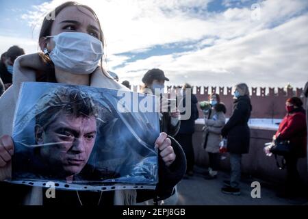 Moskau, Russland. 27th. Februar 2021 EINE Frau hält ein Porträt von Boris Nemzow in der Nähe der Stelle, wo der russische Oppositionsführer Boris Nemzow erschossen wurde, in Moskau, Russland, die Menschen bei Moskworetski (Moskauer Fluss) versammelt Brücke in der Nähe des Kremls zum Gedenken an einen russischen Oppositionsführer, der vor sechs Jahren auf einer Brücke neben dem Kreml niedergeschossen wurde Stockfoto