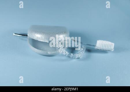 Eine Zahnschiene liegt in einer offenen Aufbewahrungsbox. Es gibt eine Zahnbürste Stockfoto