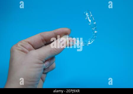 Eine Zahnschiene wird von einer Hand gehalten Stockfoto