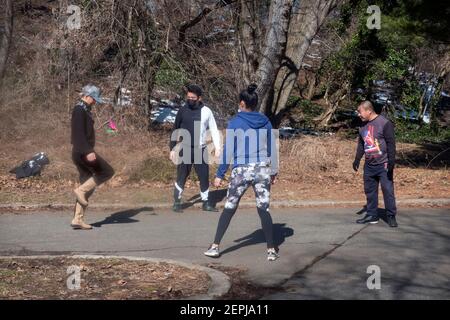 4 chinesisch-amerikanische New Yorker spielen Jianzi, ein Spiel, bei dem das Ziel ist, den schwer gewichteten Federball in der Luft zu halten. In Flushing, Queens, NYC. Stockfoto