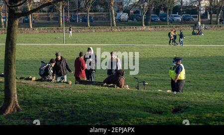 Brighton UK 27th February 2021 - Polizei-Community-Support-Offiziere überprüfen Menschen, die sich heute im Level Park im Stadtzentrum von Brighton versammeln, da die Sperrbeschränkungen in England weiter bestehen : Credit Simon Dack / Alamy Live News Stockfoto