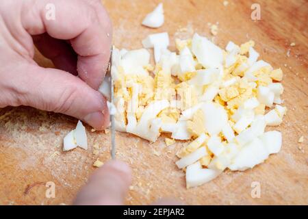 In Scheiben geschnittene gekochte Hühnereier auf der Küchenbrettplatte. Vorbereitung der Zutat für das Gericht. Hausgemachte Küche Stockfoto