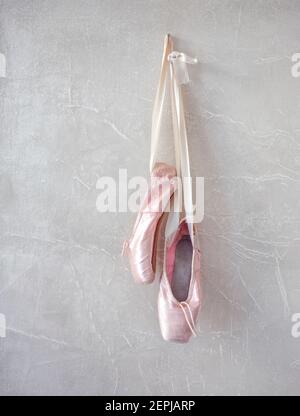 Ein Paar getragene Ballet spitzenschuhe, die an einer Wand hängen. Stockfoto