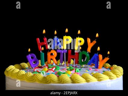 Buchstaben-förmige Kerzen buchstabieren "Happy Birthday" auf einer Geburtstagstorte. Stockfoto