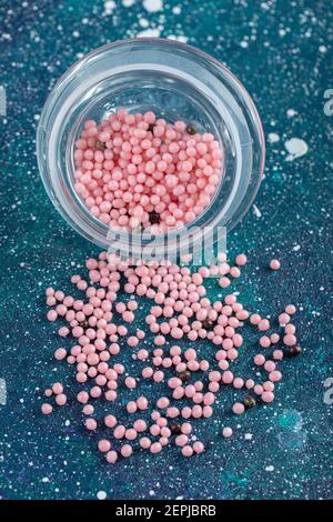 Glas rosa Süßigkeiten auf blauem Hintergrund Stockfoto