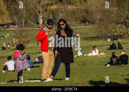 London, Großbritannien. Februar 2021, 27th. Selfies auf dem Parliament Hill - das schöne Wetter in Hampstead ermutigt die Menschen, sich im Freien zu treffen. Es ist ziemlich voll, trotz Lockdown 3, wie die Menschen frische Luft und Bewegung suchen. Kredit: Guy Bell/Alamy Live Nachrichten Stockfoto