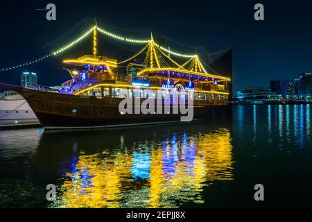 Dubai, VAE, 23. November 2020: Blick auf den Dubai Creek im alten Dubai in Al Seef. Wunderschön beleuchtete Dhau Kreuzfahrt angedockt mit einer atemberaubenden Reflexion auf dem w Stockfoto