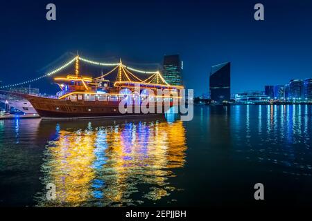 Dubai, VAE, 23. November 2020: Blick auf den Dubai Creek im alten Dubai in Al Seef. Wunderschön beleuchtete Dhau Kreuzfahrt angedockt mit einer atemberaubenden Reflexion auf dem w Stockfoto