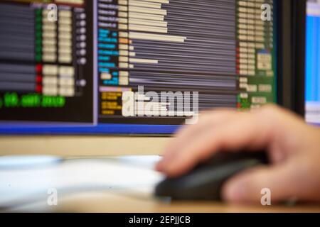 Zentralheizung. Thermometer an der Warmwasserzuleitung zum Heizsystem. Techniker trägt rote Jacke mit weißem Helm. Stockfoto