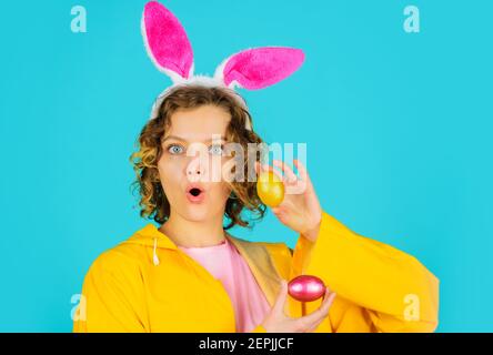 Überrascht Osterfrau mit Korb Eier. Bunny Mädchen mit Kaninchenohren Vorbereitung für traditionelle Eierjagd Spiel. Stockfoto