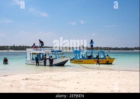 Glasbodenboote, die von einer Ebbe-Sandbank mit Menschen am Strand, Diani, Kenia, vertäut sind Stockfoto