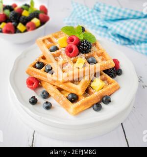 Waffeln mit Puderzucker und frischem Obst. Stockfoto