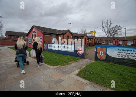 BELFAST, NORDIRLAND - Februar 24: Zwei Frauen passieren Stammesurkunden in der „Freedom Corner“, Newtownards Road, Belfast. Stockfoto