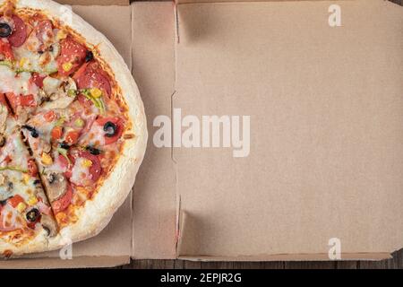 Draufsicht auf die Hälfte der gemischten Pizza auf der Box Stockfoto