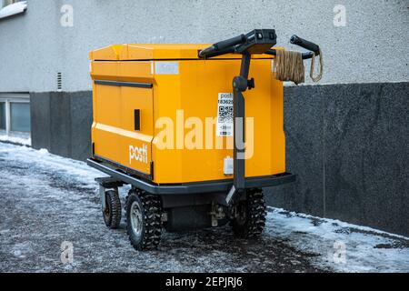 E-Mail-Lieferwagen oder Trolley mit Posti-Logo und Markenfarbe Stockfoto